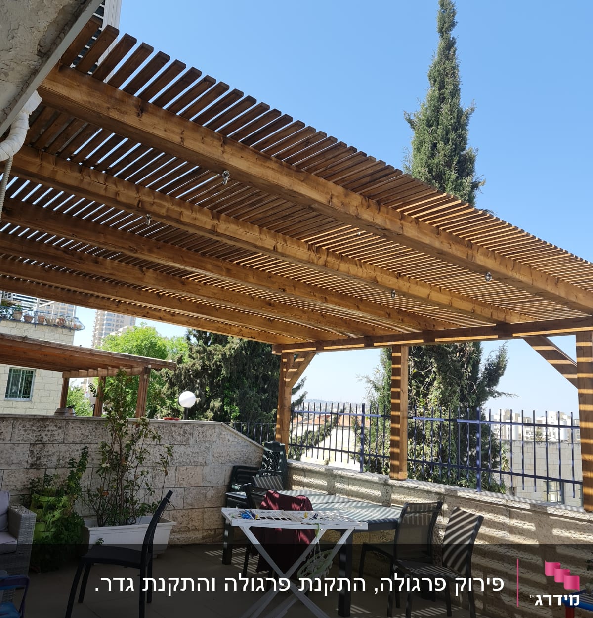 פרגולה מעץ עם כיסאות ושולחן בגינה